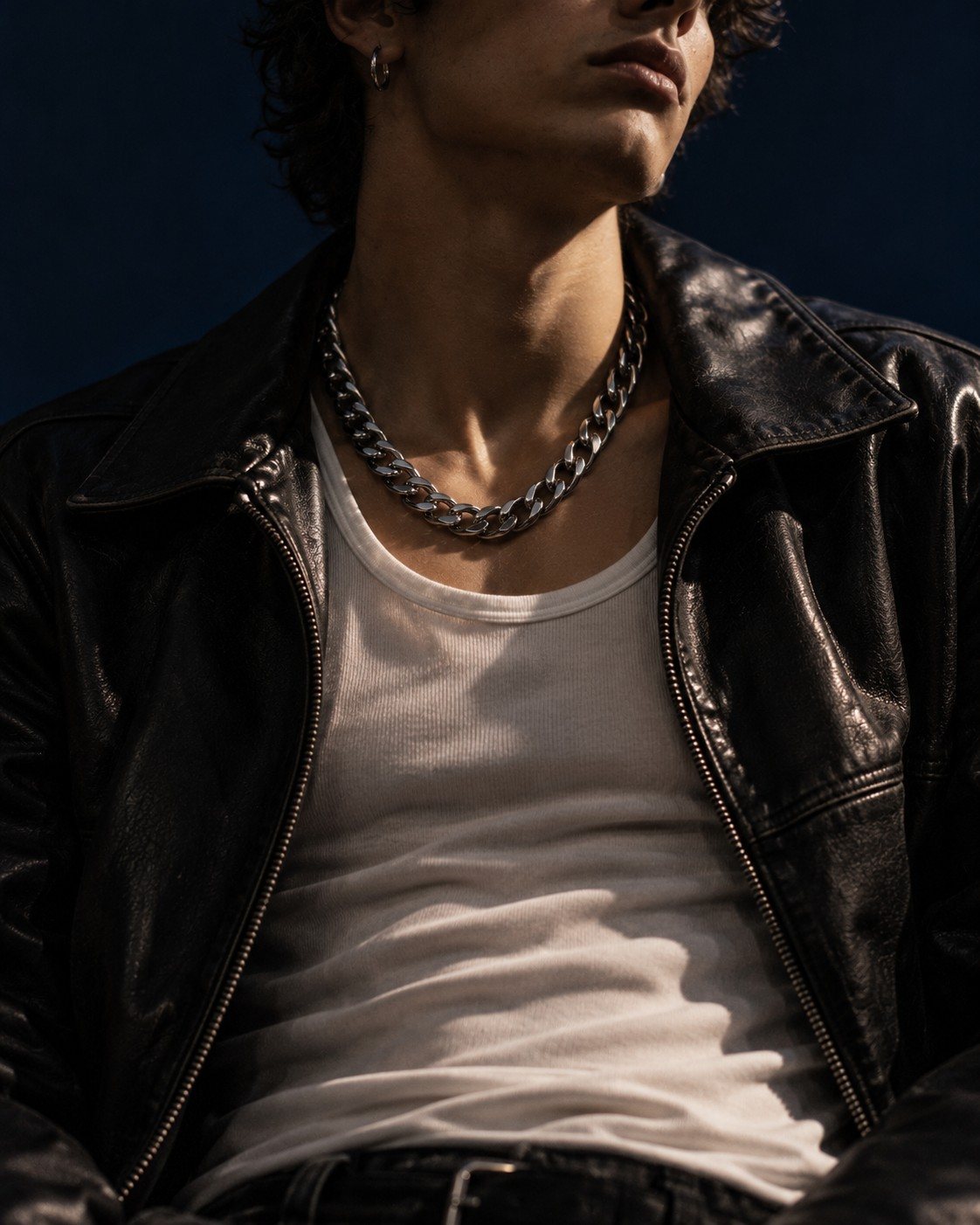 Heavy silver curb chain over a white tank and black leather jacket